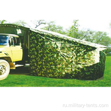 Камуфляжная военная палатка с одной стороны автомобиля